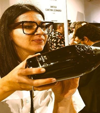 Cristina Binotto of Andreola pouring a bottle at a tasting event